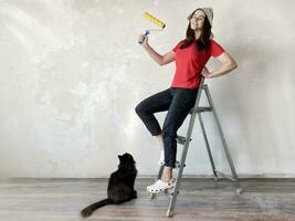 Happy woman going to do home repairs with black cat photo