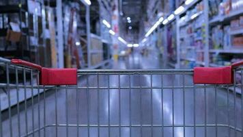 View from the empty shopping cart of the shop. Shopping carts through the household aisles of supermarkets. video