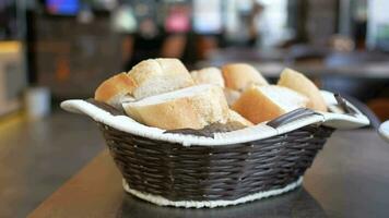 Bread in wicker wooden basket on cafe table . video