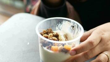 spoon pick breakfast cereal from a plastic container outdoor video