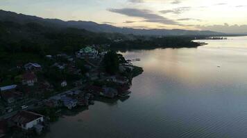 Aerial view of the road by the lake and mountains video