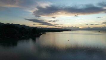 Aerial view over the water of the lake with sunset views and sun reflections. Aerial view of lake. Flying over water. Flight over calm lake surface video