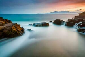 un largo exposición fotografía de un rocoso playa a puesta de sol. generado por ai foto