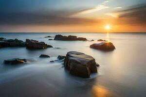 a long exposure photograph of rocks on the beach at sunset. AI-Generated photo