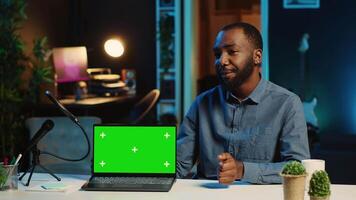 Content creator in studio films newly released green screen gaming laptop video review for tech enthusiasts. Viral online star hosts technology internet show, unboxing mockup notebook device