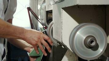 Craftsman using grinder machine while making shoes video