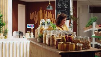 clientes compras en eco simpático cero residuos supermercado correr por celoso Encargado de tienda. clientela adquisitivo recién cosechado comida desde ambientalmente simpático local barrio Tienda video