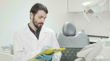 Professional dentist filling medical documents at his office video
