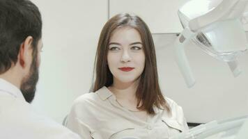 charmant femme vérification sa les dents dans le miroir à dentaire clinique video