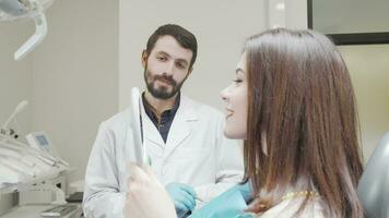tandläkare talande till patient medan hon utseende i de spegel efter dental behandling video