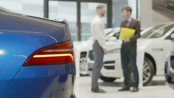 Car dealer shaking hands with male client at automobile dealership video