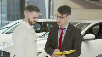 Handsome man signing papers at dealership after buying new automobile video