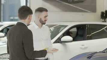 Beau homme d'affaire parlant à vendeur à voiture concession video