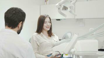 Happy woman looking in the mirror after dental checkup video