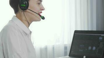 Sliding shot of a female call center operator working on a computer video