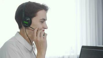 affascinante giovane donna sorridente per il telecamera mentre Lavorando a chiamata centro video