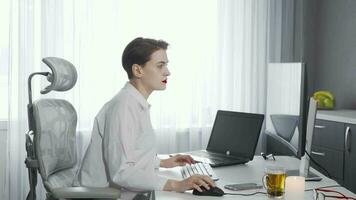 femmina libero professionista utilizzando sua inteligente Telefono mentre Lavorando su un' computer video