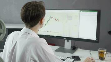 Female stock trader smiling to the camera while working on her computer video