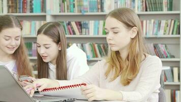 adolescent écolière travail sur un affectation à le bibliothèque video