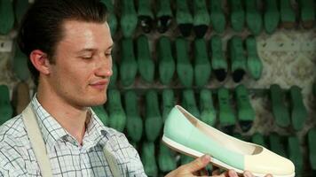 Handsome male shoemaker smiling to the camera at his workshop video