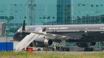 NOVOSIBIRSK, RUSSIAN FEDERATION JULY 15, 2022 - Plane of Azur Air with Lujo Art Joy Livery on the apron. Premium jet aircraft at terminal. Tourism and travel concept video