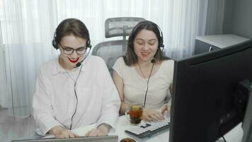 Top view shot of two female call center operators working online together video