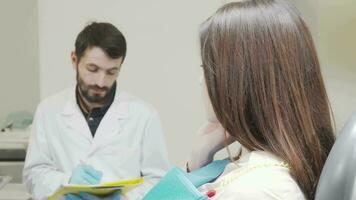 femme avec mal aux dents à la recherche à le caméra séance dans dentaire chaise video