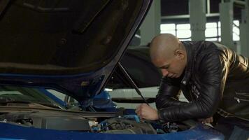 Cheerful handsome African man smiling to the camera while working at his garage video