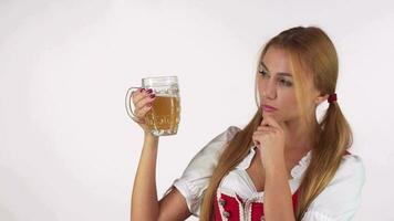 Woman examining beer in a mug thoughtfully video