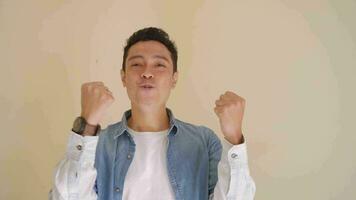 Young Indonesian man with denim style cheers pose and gesture.  The footage is suitable to use for man expression and fashion life style. video