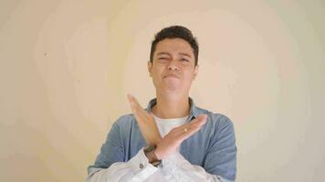Young Indonesian man with denim style stop gesture.  The footage is suitable to use for man expression and lifestyle content media. video