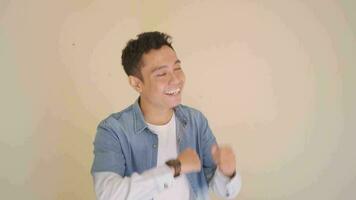Young Indonesian man with denim style dance and sing a song.  The footage is suitable to use for man expression and fashion life style. video