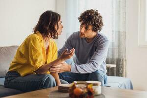 hombre y mujer son sentado a sofá y discutiendo. relación problemas. foto