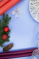 regalo rollos de papel, pino cono, arco y cinta, abeto ramas con Navidad pelotas en azul antecedentes. nuevo año Navidad. accesorios para regalo envase foto
