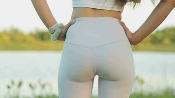 Young woman stretching before running while looking for beautiful landscape on roadside. Sports and Recreation video