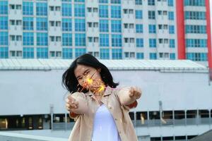 happy asian young woman hipster holding sparklers firework celebrate new year eve with dancing in roof top apartment with urban building background photo