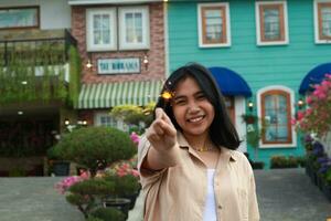 happy young asian woman holding sparkler enjoy new year eve celebration in outdoor garden of colorful vintage house in evening photo