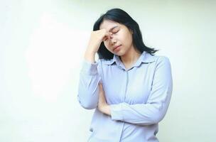 depressed asian woman feeling unwell tired having headache touching forehead with folded arm isolated on white background photo