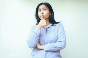 beautiful pensive asian woman daydreaming looking away woth thumbs up kiss by lips with arm folded wear formal suit isolated by white background photo