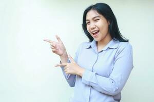 presenting asian young woman pointing finger to side looking to camera smiling with excitement, wearing formal shirt isolated on white background photo