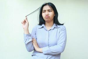 portrait of beautiful asian business woman feeling upset and dissatisfied looking away and pulling her hair with arm folded isolated in white background photo