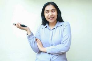 happy peaceful asian business young woman holding mobile phone with folded arm and raising palm looking away with bright smile wearing formal shirt standing over isolated background photo