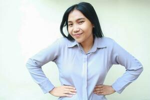 image of charming asian young business woman look at camera pleasantly with hand on waist wearing formal office clothes standing over isolated white background photo