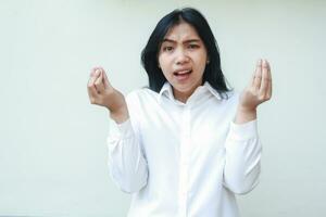 image of stress asian woman arguing with boss pose, look at camera asking gesture with raising hands, wearing formal shirt standing over isolated background photo