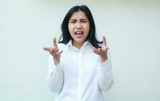 what do you want. angry asian woman looking at camera with frowning face expression and shrugging shoulders keep palms sideways questioning gesture wearing white formal office clothes isolated photo