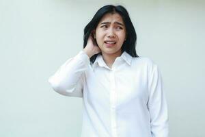 image of anxious asian young business woman dressed in white formal suit shirt grabbing her dark hair look away frightened, feeling tired of overworked, regreting mistakes she made cause trouble photo