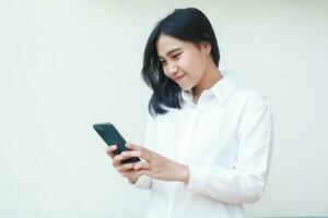 beauty grateful asian business woman satisfied online shopping via smartphone, browsing social media read good news, try new apps, wearing white formal suit shirt, standing isolated photo