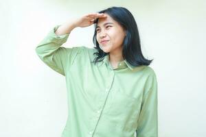 pleased stylish asian woman wearing green over size shirt smiling looking away with raising hands over forehead standing isolated white background photo