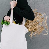 Young girl holding a cloth bag with ears of wheat photo