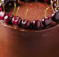 Chocolate cake decorated with sweet cherries photo